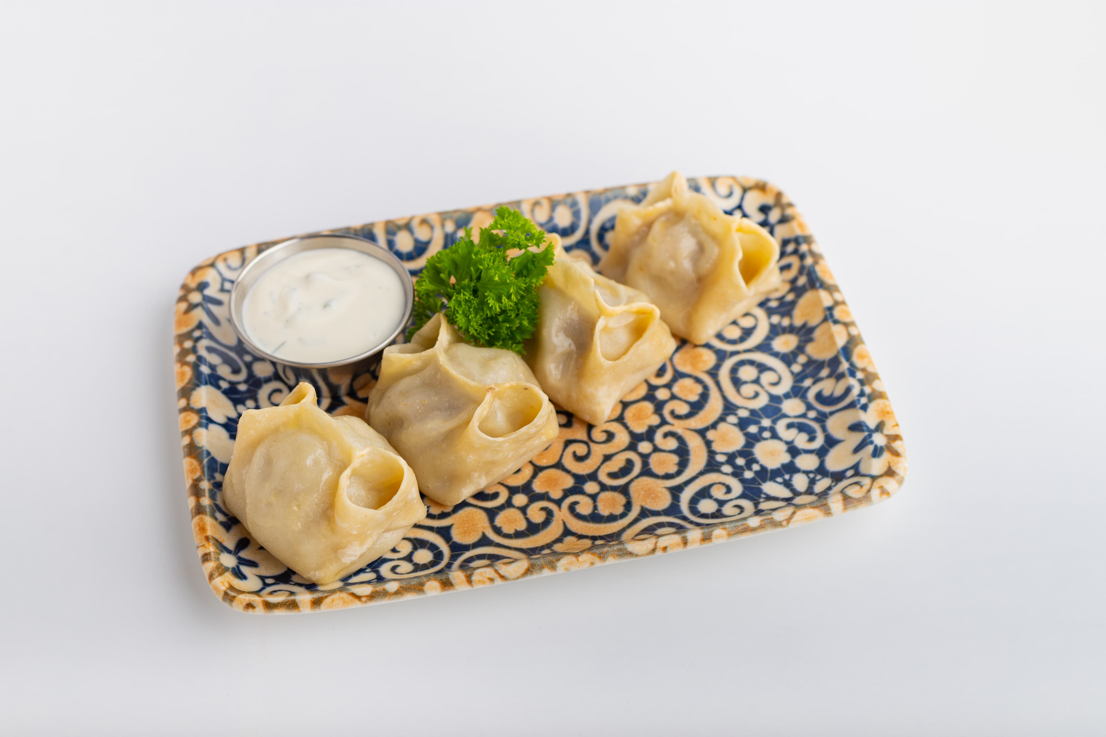 Манты с говядиной, сметанным соусом и зеленью